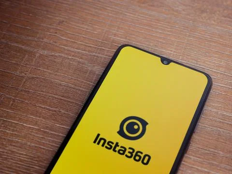 Insta360 app launch screen on smartphone on wooden background. Stock Photos
