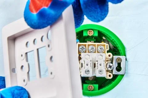 Instalation of light switch by worker. Stock Photos