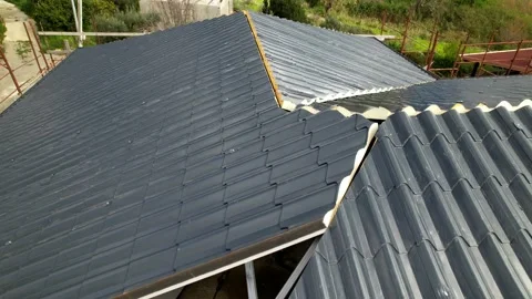 Installation of anthracite metal roofing tiles on a complex building. Stock Footage 330133434
