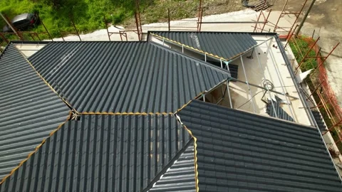 Installation of anthracite metal roofing tiles on a complex building. Stock Footage 330133523