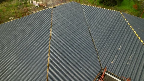 Installation of anthracite metal roofing tiles on a complex building Stock Footage 330133544