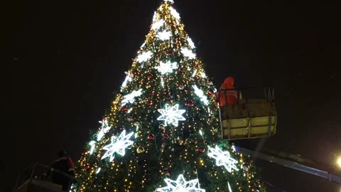 Installation of an artificial Christmas tree street view snowfall Stock Footage 226393649