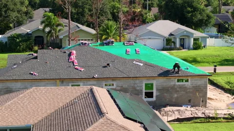 Installation of asphalt shingles on modern home rooftop. Construction work in Stock Footage 344695914
