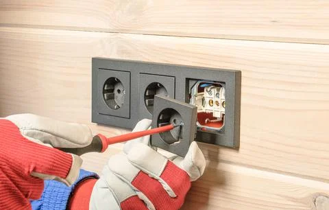 Installation of a block of three black sockets on a wooden wall Stock Photos