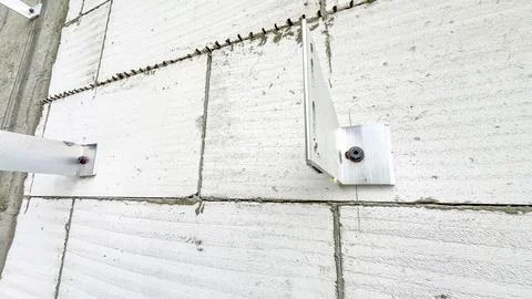 Installation of brackets on building for installation of ventilated facade. Alum Stock Photos
