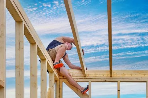 Installation of ceiling beams during construction of timber frame house, yo.. Stock Photos
