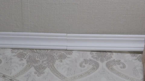 Installation of a ceiling skirting board on liquid nails to a ceiling, a wall. Stock Footage 148229706