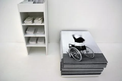 Installation composition of a stack of photos and bookshelves on a clean light Stock Photos