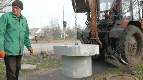 Installation of covers of cable shafts. Using an excavator tractor. Stock Footage 127083332