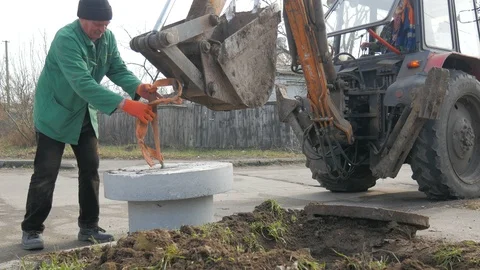 Installation of covers of cable shafts. Using an excavator tractor. Stock Footage 127187719