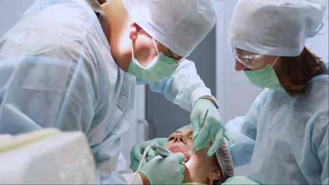 Installation of dental implants in modern dental clinic. Oral surgeon and nurse Stock Footage 270900831