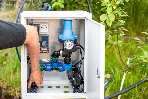 Installation of a drip irrigation system. A man installs an Automatic Water.. Fotos de archivo