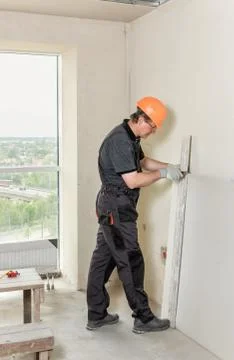 Installation of drywall. The worker is cutting plasterboard. Stock Photos