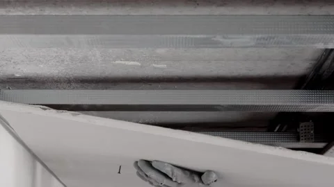 Installation of drywall. Workers are using screws and a screwdriver  Stock Footage 246598621