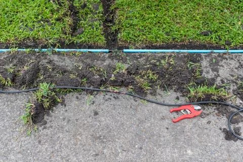 Installation of electric wire or cable on ground, blue plastic pipe Stock Photos