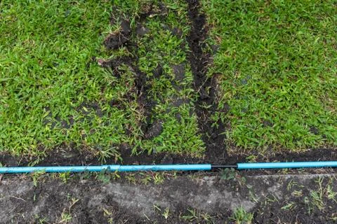 Installation of electric wire or cable on ground, blue plastic pipe Stock Photos