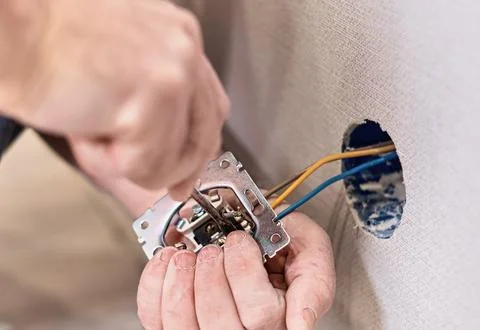 Installation of electrical sockets. Hands an electrician installing an elec.. 库存照片