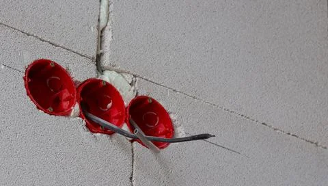 Installation of electrical wiring, red plastic boxes and electrical cables on Foto stock