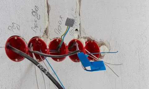 Installation of electrical wiring, red plastic boxes and electrical cables on Stock Photos