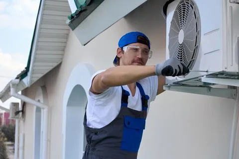 Installation external air conditioner unit using screwdriver fastening holders Stock Photos