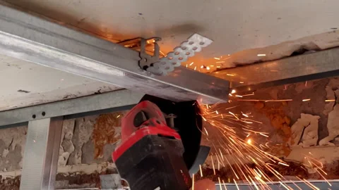 Installation of a frame for drywall indoors. A worker cuts off an element of a m Video stock 247205597