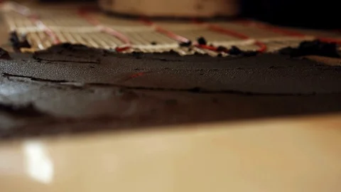 Installation of heated floor. Laying a ceramic or porcelain tile floor close- Stock Footage 109184553