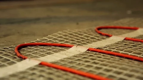 Installation of heated floor. Laying a ceramic or porcelain tile floor close- Video stock 109184578