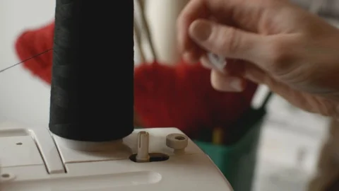 Installation a large bobbin with black thread for winding on a sewing machine Stock Footage 128966787