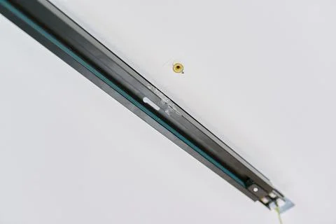 Installation of LED ceiling mounted modern track downlight. Stock Photos