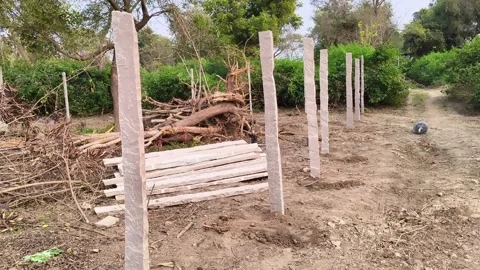 Installation of natural stone fence posts for wire fencing Stock Footage 325416367