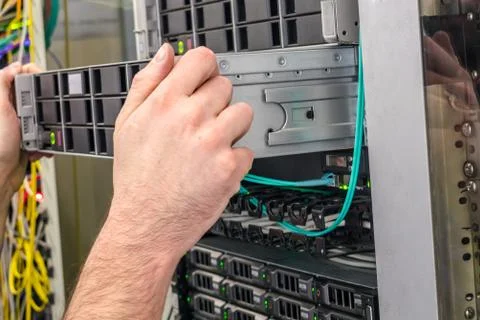 Installation of a new server in a rack with computer equipment is close up. S 库存照片