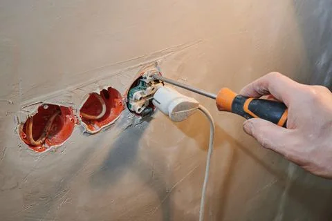 Installation of a new socket in a freshly plastered wall with plug connection Stock Photos
