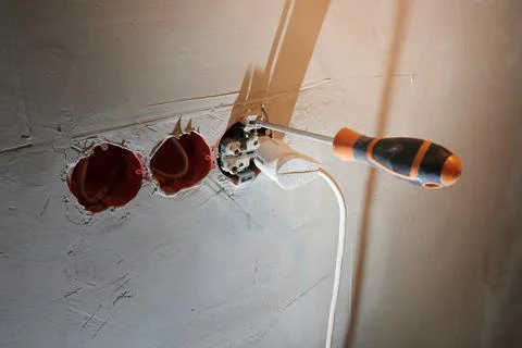 Installation of a new socket in a freshly plastered wall with plug connection Stock Photos