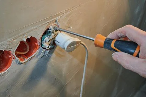 Installation of a new socket in a freshly plastered wall with plug connection Stock Photos