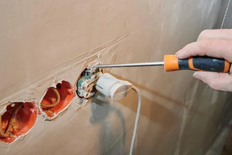 Installation of a new socket in a freshly plastered wall with plug connection Stock Photos