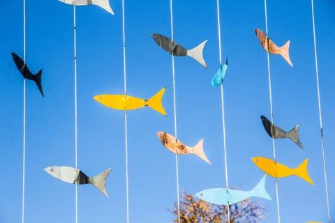 Installation in the Park colored fish on a wire against the blue sky Stock Photos