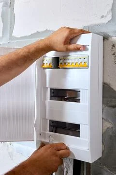 Installation of plastic internal electrical box or cabinet in utility room of Stock Photos