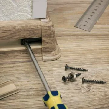 Installation of a plastic skirting on outer corner of floor 写真素材