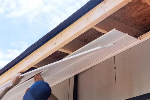 Installation of plastic vinyl soffit at ceiling corner on a rafters structure Stock Photos