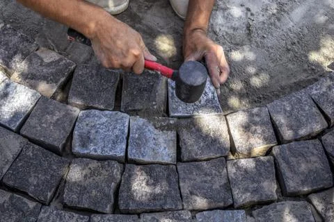 Installation process of gray granite stones during the repair of the sidewalk Stock Photos