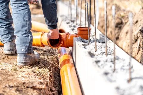 Installation of a sewage plastic pipe during the construction of a house 스톡 사진