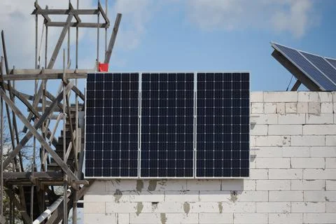 Installation of solar panels house under construction, green energy concept Stock Photos