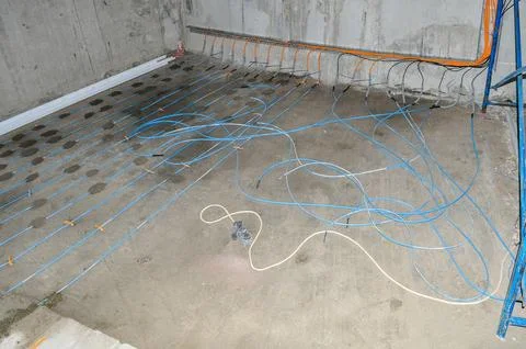 Installation of underfloor heating with blue pipes fixed with orange fastener Stock-Fotos