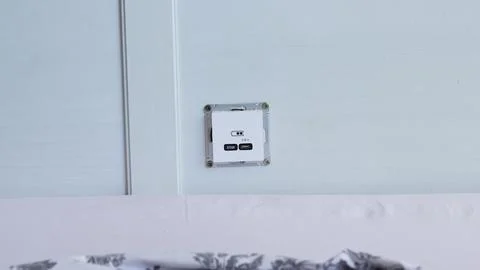 Installation of a USB Type-C socket at the head of the bed for charging devices. Stock Photos