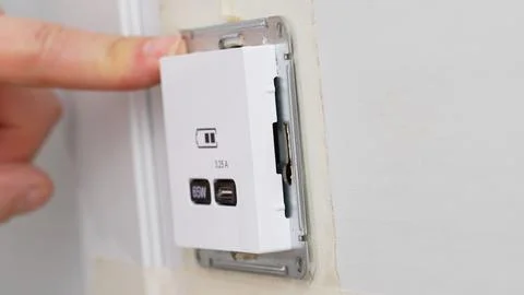 Installation of a USB Type-C socket at the head of the bed for charging devices. Stock Photos