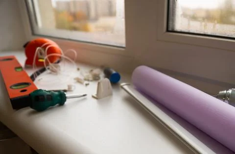 Installation of a window roller with a holder. Installation tool. Screwdrivers,  Stock Photos