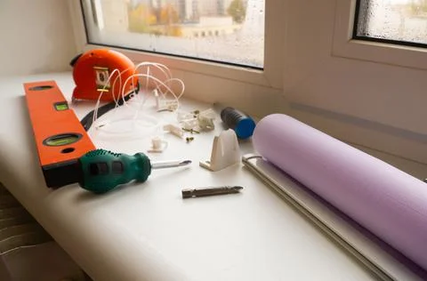 Installation of a window roller with a holder. Installation tool. Screwdrivers,  Stock Photos