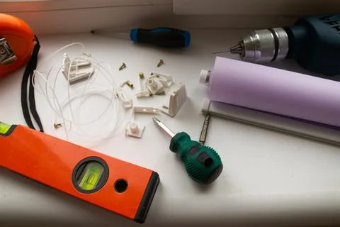 Installation of a window roller with a holder. Installation tool. Screwdrivers,  Stock Photos
