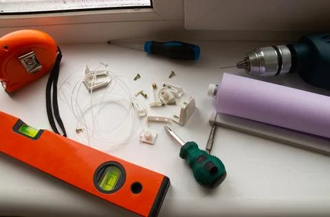 Installation of a window roller with a holder. Installation tool. Screwdrivers,  Stock Photos