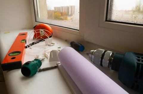 Installation of a window roller with a holder. Installation tool. Screwdrivers,  Stock Photos